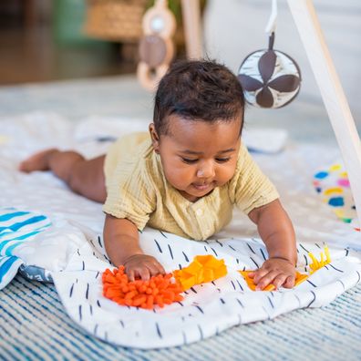 newborn playing on baby mat - Lovevery