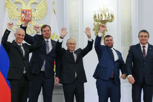 From left, Moscow-appointed head of Kherson Region Vladimir Saldo, Moscow-appointed head of Zaporizhzhia region Yevgeny Balitsky, Russian President Vladimir Putin, center, Denis Pushilin, the leader of the Donetsk People's Republic and Leonid Pasechnik, leader of self-proclaimed Luhansk People's Republic wave during a ceremony to sign the treaties for four regions of Ukraine to join Russia, at the Kremlin, Moscow, Friday, Sept. 30, 2022.  