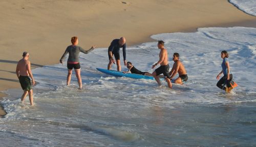 Onlookers helped as the woman was brought out of the ocean.