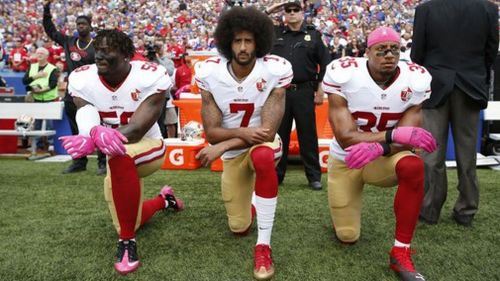 Eli Harold, Colin Kaepernick and Eric Reid kneel during the US National Anthem.