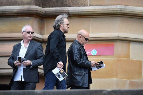 AC/DC alumni Mark Evans (middle) and Angry Anderson (right) attend St Mary's Cathedral. (AAP)