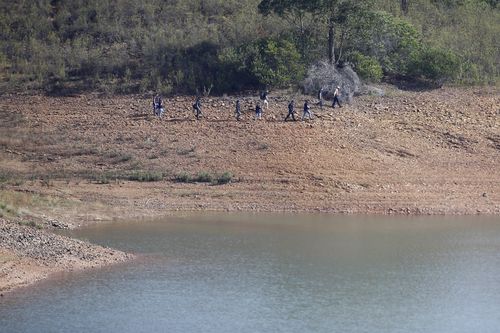A police search team work on the shore of the Arade dam near Silves, Portugal, Wednesday May 24, 2023.  