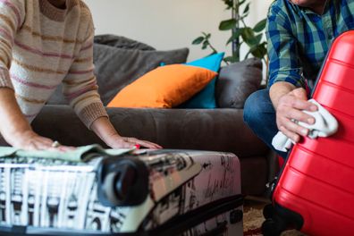 A mature couple are happy wiping their suitcases getting ready to pack for a trip