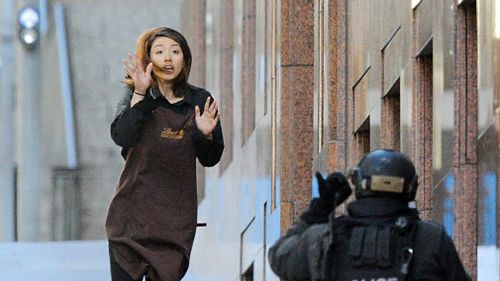 Sydney Siege hostage Elly Chen runs from the Lindt Chocolat cafe in Martin Place, Sydney, on December 15, 2014. (AAP)