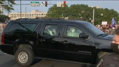 Donald Trump drives past supporters