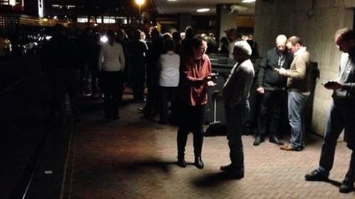 Evacuated workers stand outside the station. (Telegraaf)