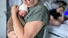 Newborn baby in the hands of her  grandmother in hospital