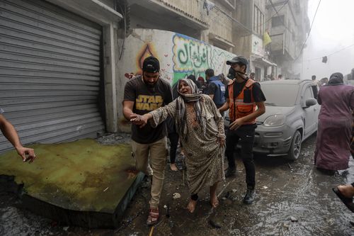 People help evacuate a Palestinian woman following Israeli airstrikes that targeted her neighbourhood in Gaza City, Monday, Oct. 23, 2023. (AP Photo/Abed Khaled)