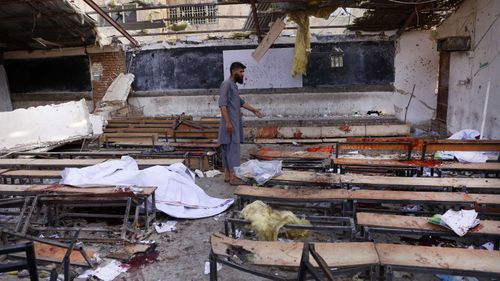 An Afghan man inspects the scene of a suicide bomb attack in Kabul.