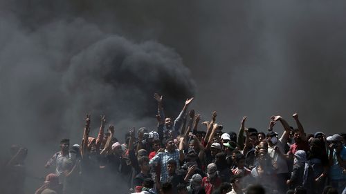 Palestinian protesters chant slogans as they burn tires during a protest on the Gaza Strip's border with Israel.