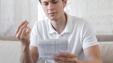 Man taking pill vitamin medication reading instructions