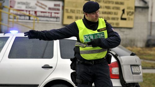 A police officer directs traffic near the restaurant where the gunman opened fire in Uhersky Brod. (AAP)