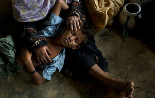 A young Rohingya boy is comforted at a refugee camp. (AP)