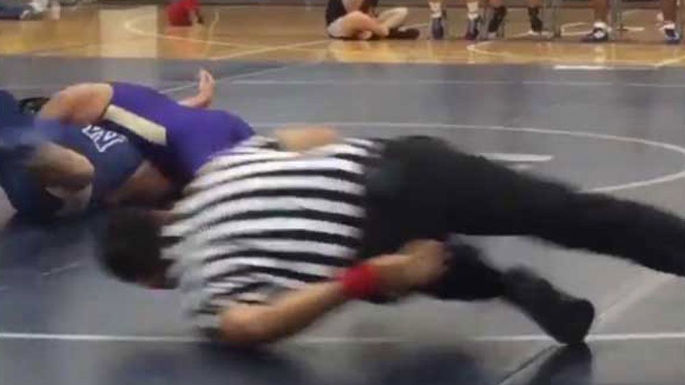 High school wrestling referee's hilarious eel-like slide across floor goes viral