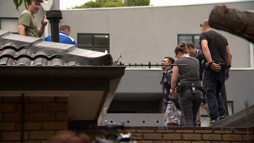 Police coaxed the suspect down from the roof, then arrested him.