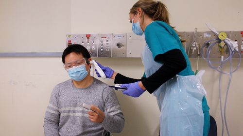 A nurse checking a patient's temperature.