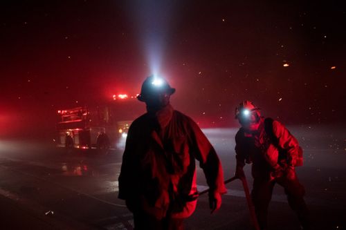 Firefighters scramble to setup hose lines during the Woolsey Fire in Thousand Oaks