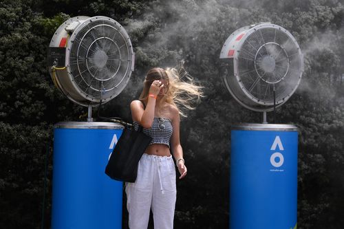 A spectator at the Australian Open in Melbourne cools down in front a massive fan.