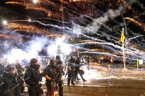 Police use chemical irritants and crowd control munitions to disperse protesters during the 100th consecutive day of demonstrations in Portland