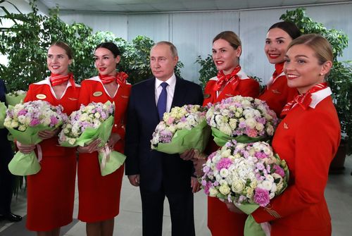 Russian President Vladimir Putin poses for a photo during his meeting with representatives of the flight crew of Russian airlines as he visits to Aeroflot Aviation School outside Moscow, Russia, Saturday, March 5, 2022 