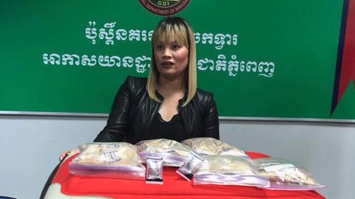 Ve Thi Tran pictured with her suitcase and the heroin allegedly found inside it. (Image: Cambodia General Department of Immigration/Facebook)