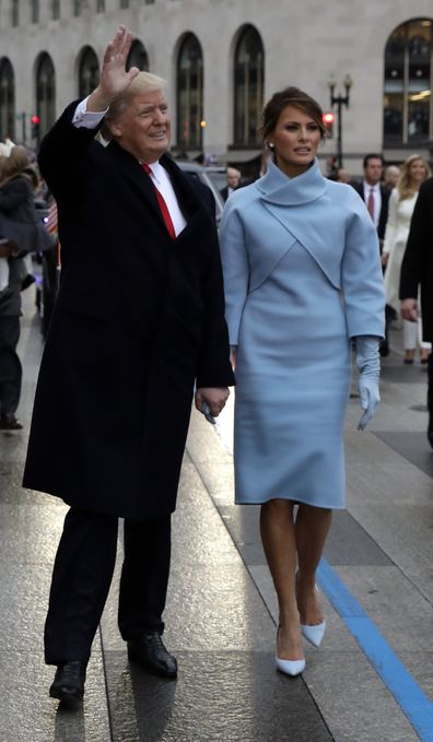 President Donald Trump waves as he walks with first lady Melania Trump during the inauguration parade on Pennsylvania Avenue in Washington, Friday, Jan. 20, 2017. 