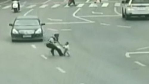 The heart-stopping moment the policeman ran onto the busy road to save the endangered toddler. 