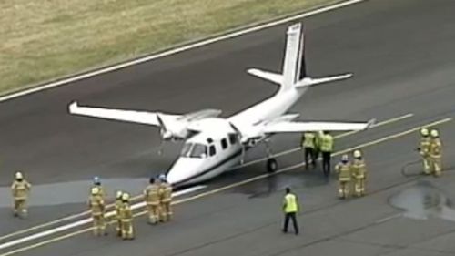 Emergency crews surround the plane after it touches down. (9NEWS)