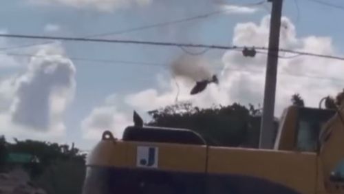 A helicopter is seen on fire before crashing into a unit block in Florida.