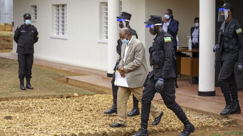 Paul Rusesabagina, center, whose story inspired the film "Hotel Rwanda", is led out in handcuffs from the Kicukiro Primary Court in the capital Kigali, Rwanda Monday, Sept. 14, 2020