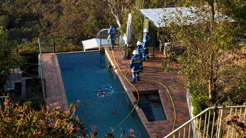NSW Fire &amp; Rescue Community Fire Unit (CFU) is seen protecting properties under threat from spot fires in Berowra Heights. (AAP)