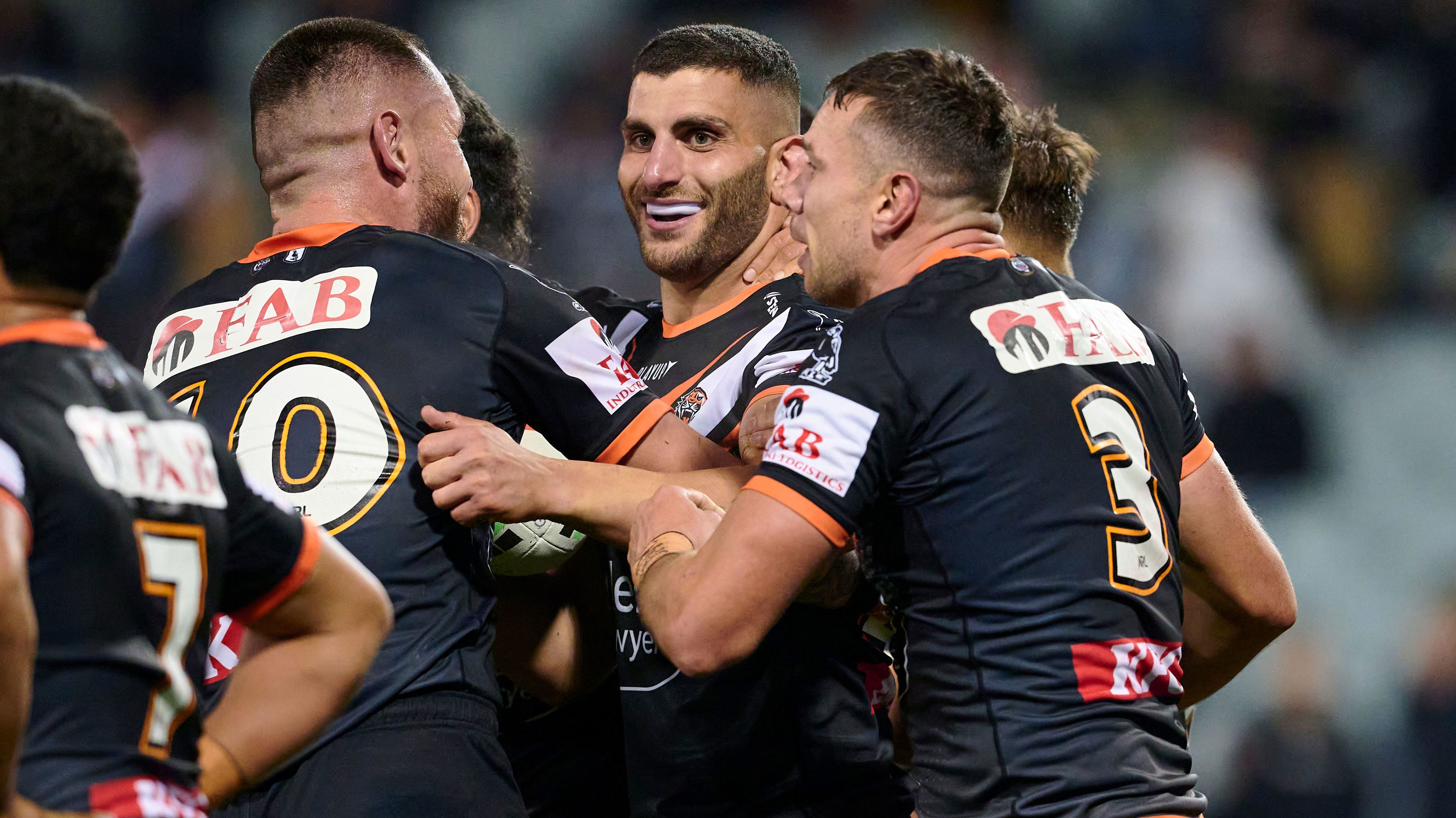 Alex Twal celebrates with Tigers teammates after scoring his first NRL try.