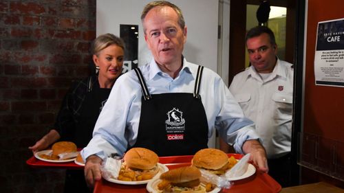 Bill Shorten and his wife Chloe serve food during a visit to the Salvation Army's Lighthouse Cafe in Melbourne on Friday.