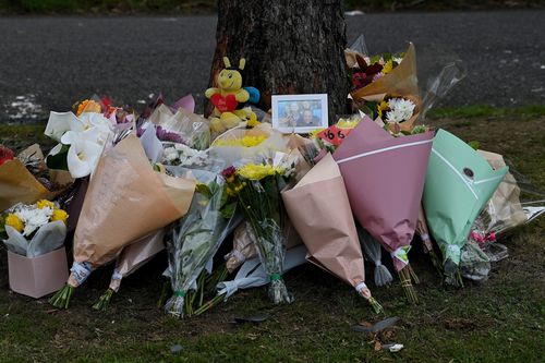 A framed photo with a halo above a girls head is placed at the base of a tree where 5 people were killed in a motor vehicle accident last night on East Parade in Buxton, NSW. 7th September, 2022. Photo: Kate Geraghty