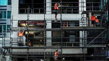 Workers are seen taking down cladding ahead of the first view of the North Sydney Metro station, in North Sydney, Friday, 31 May 2024.