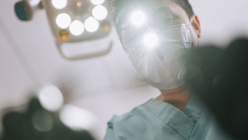 Dentist looks down on patient.