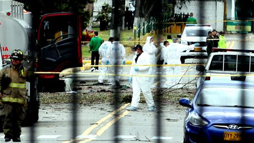 Forensics experts pick their way through the bomb site