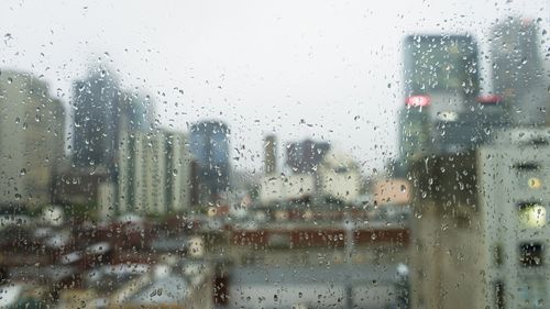 As gotas de chuva na janela olham para o clima triste em Melbourne, Austrália. Campo de profundidade rasa com foco em gotas de chuva.