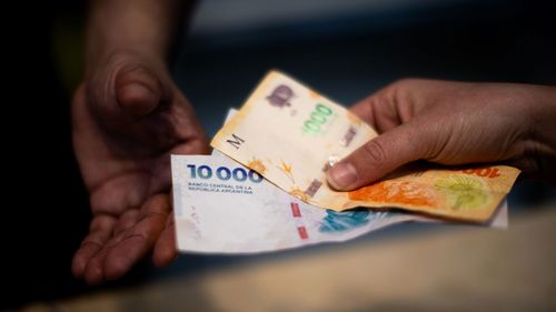 Um cliente paga comida com notas de peso argentino no distrito financeiro de Buenos Aires, Argentina, em 8 de setembro.