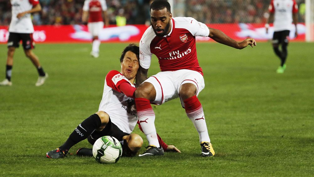 Arsenal's record signing Alexandre Lacazetta shrugs off Wanderers midfielder Jumpei Kusukami. (AAP)