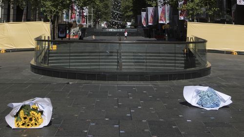 Bouquets of hydrangeas and sunflowers are placed on the memorial - the favourite blooms of the victims. (AAP)