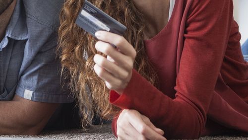 Woman holding credit card next to husband