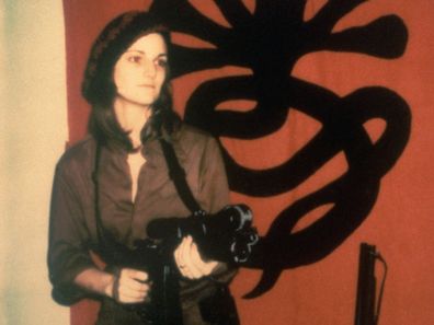 Kidnapped heiress Patty Hearst holding a machine gun.