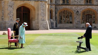 Queen Elizabeth II awards Captain Sir Thomas Moore with the insignia of Knight Bachelor at Windsor Castle on July 17, 2020 in Windsor, England.