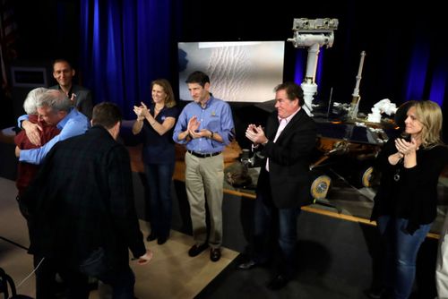 Scientists and other NASA officials applaud and embrace after a mission briefing for the Mars Exploration Rover Opportunity at NASA's Jet Propulsion Laboratory in California.