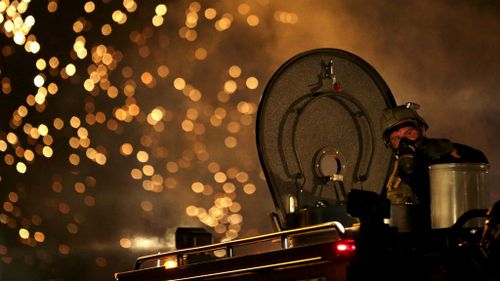 A law enforcement officer on a tactical vehicle watches after a device was fired to disperse a crowd. (AP)