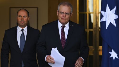 Prime Minister Scott Morrison and Treasurer Josh Frydenberg arrive to speak to the media during a press conference at Parliament House in Canberra.