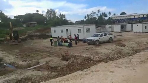 The footage shows one man digging a hole beside a concrete mixer, and construction workers studying a segment of pipe. (Ezuthullah Kalar)