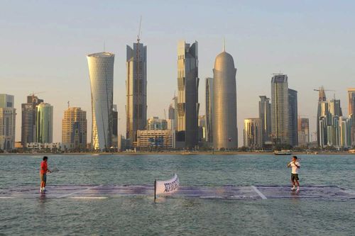 Roger Federer and Spanish Rafael Nadal playing tennis on a suspended artificially prepared tennis court at the Doha palm tree island in Doha, Qatar