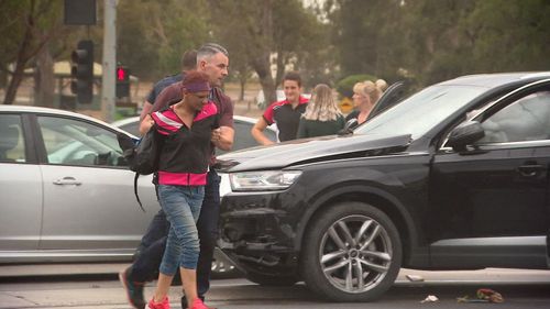 Police handcuff the female suspect at the crash scene.